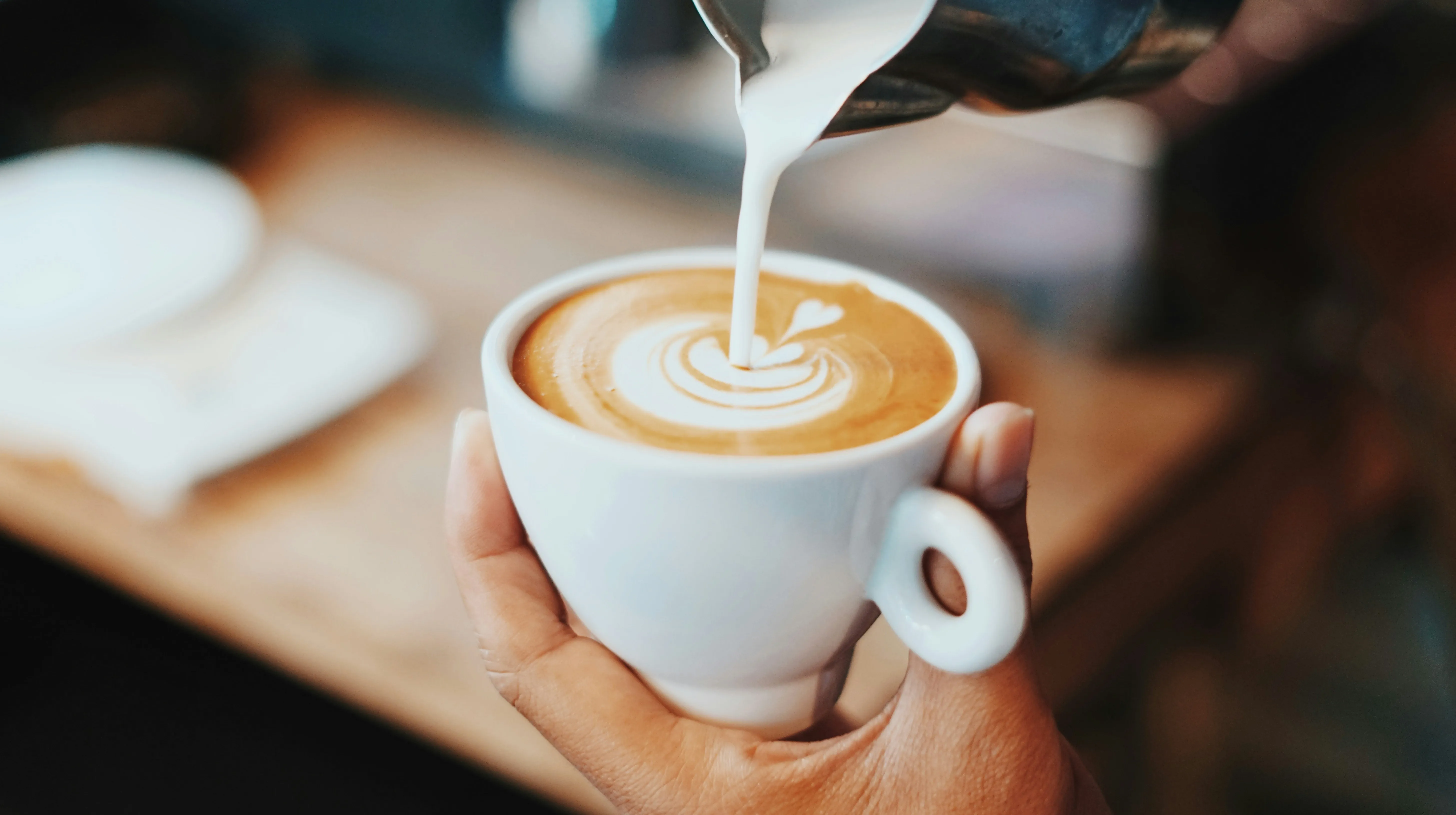 cofee being poured into a cup with coffee art