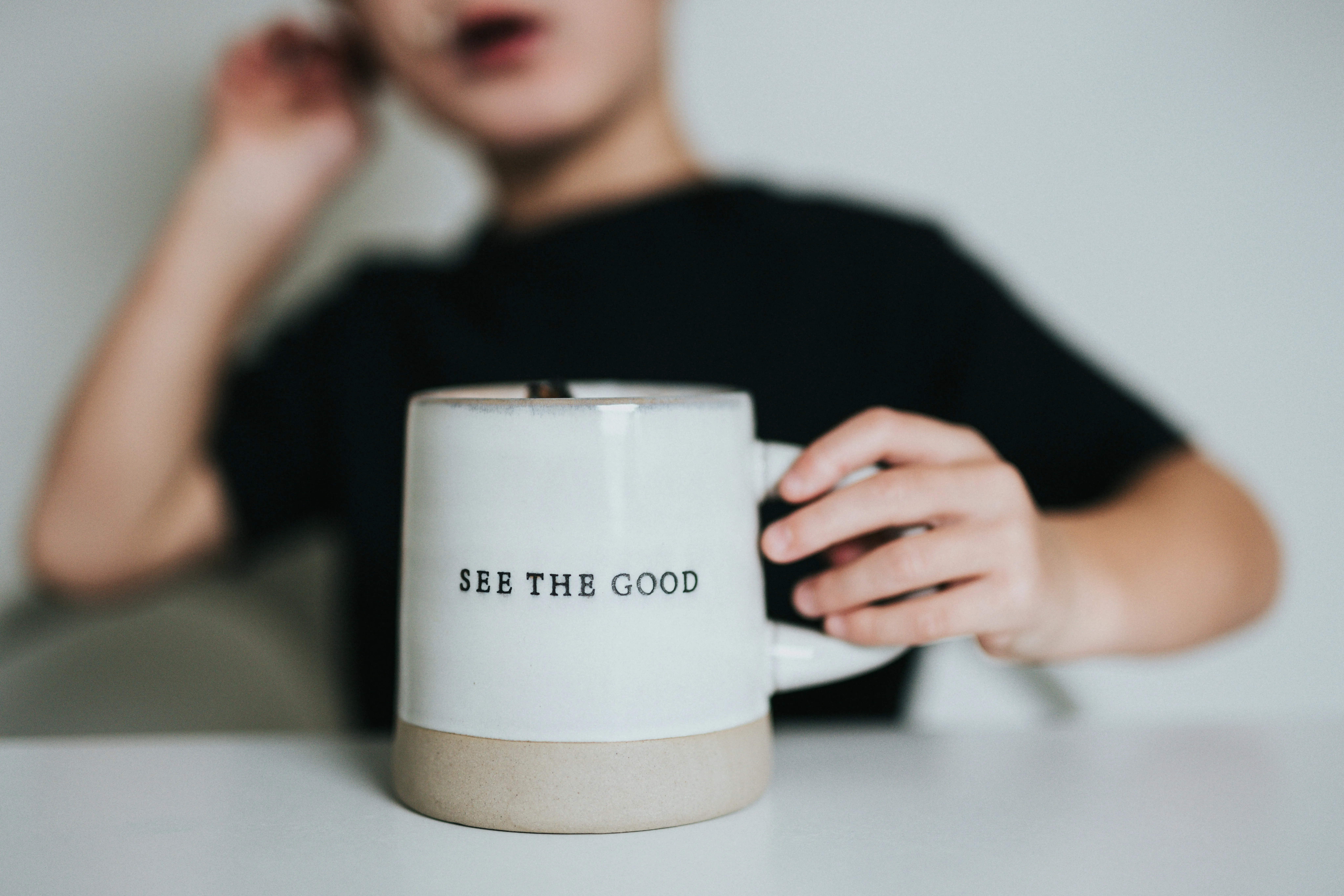 a person holding a cup saying: See the Good